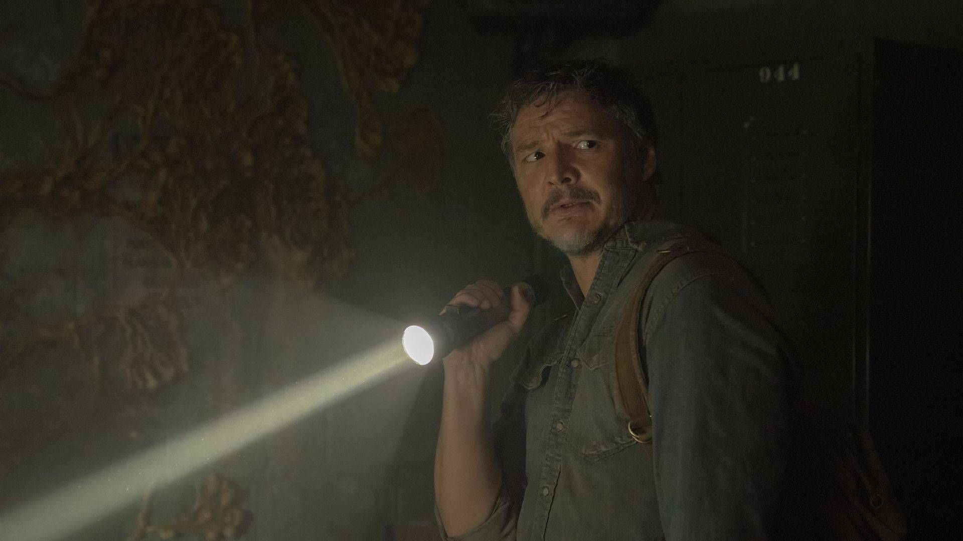 Joel segurando uma lanterna ligada na direita